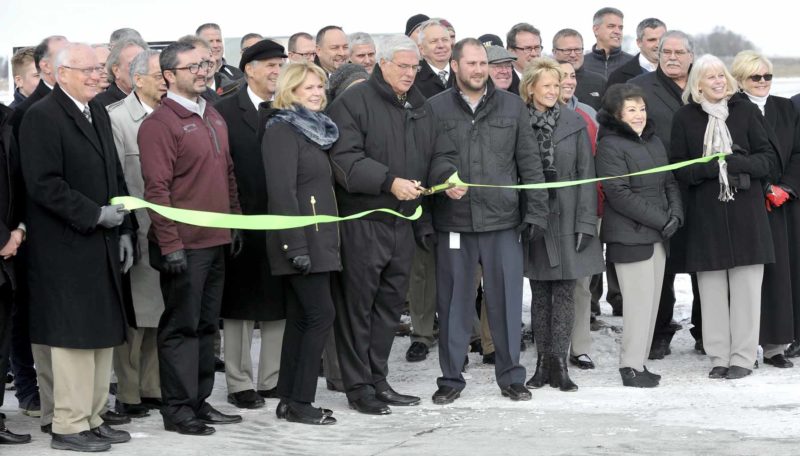 -Messenger photo by Hans Madsen Decker Truck Lines, Inc. Chairman of the Board Don Decker, center, cuts the ribbon Thursday morning for the Decker Development Park on the east side of Fort Dodge. The site has over 100 acres of land available for commercial development.